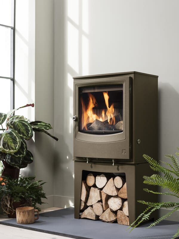 Arada Farringdon Small Eco multifuel stove shown in optional Chestnut colourway and on optional colour-matched log store accessory