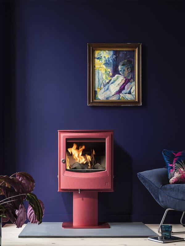 Arada Farringdon Small Eco multifuel stove shown in optional Spice colourway and on optional colour-matched pedestal accessory